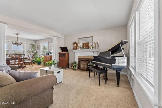 a living room with furniture a piano and a flat screen tv