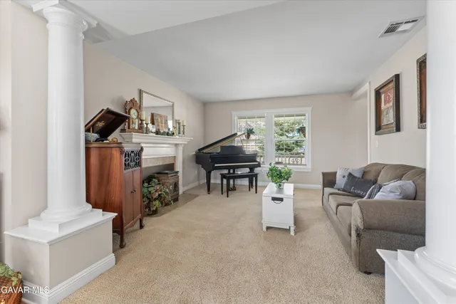 a living room with furniture and a dining table with chair