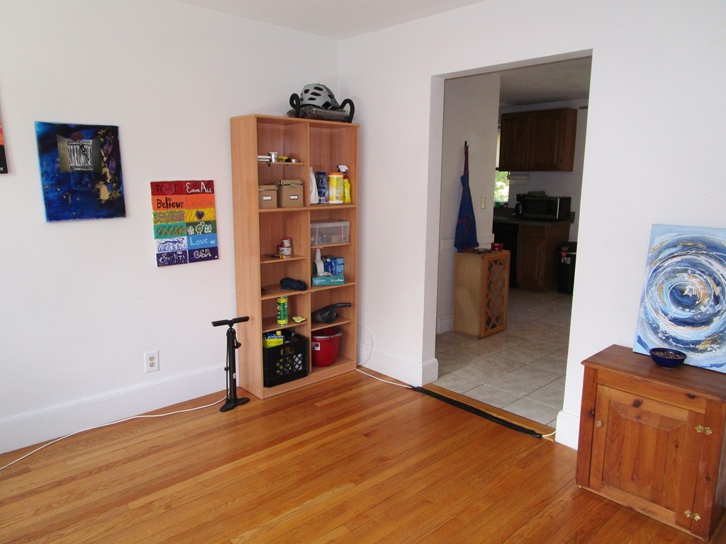 6 O'Leary Way, Unit 82 Boston, MA 02130 - Photo 3 of 14 a view of empty room with wooden floor and book shelf