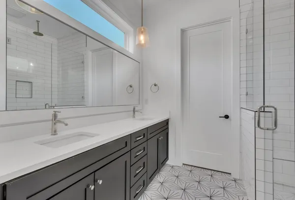 a bathroom with a double vanity sink a mirror and a shower