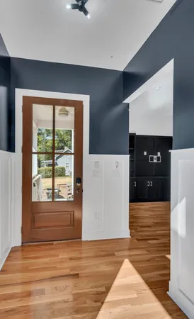 a view of hallway with window and wooden floor