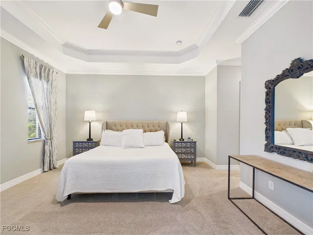 a bedroom with a bed and a large mirror on dresser