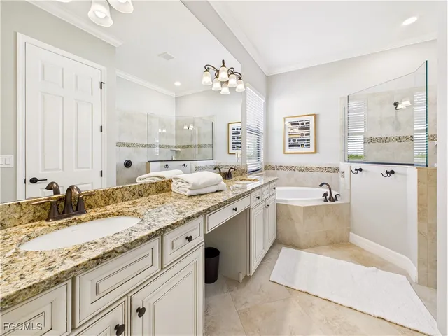 a spacious bathroom with a granite countertop sink mirror and a bathtub
