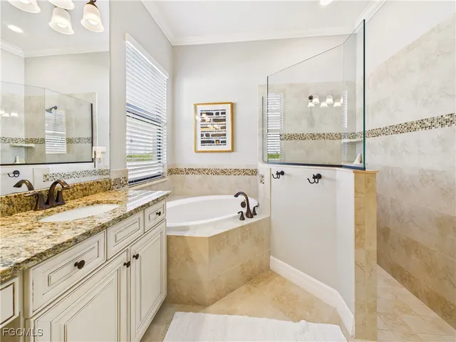 a spacious bathroom with a granite countertop tub sink and mirror