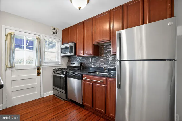a kitchen with stainless steel appliances granite countertop a refrigerator and a stove top oven