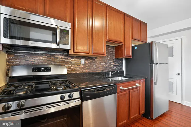 a kitchen with stainless steel appliances granite countertop a stove microwave and refrigerator