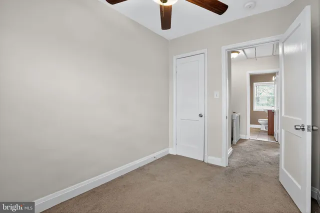 an empty room with closet and windows