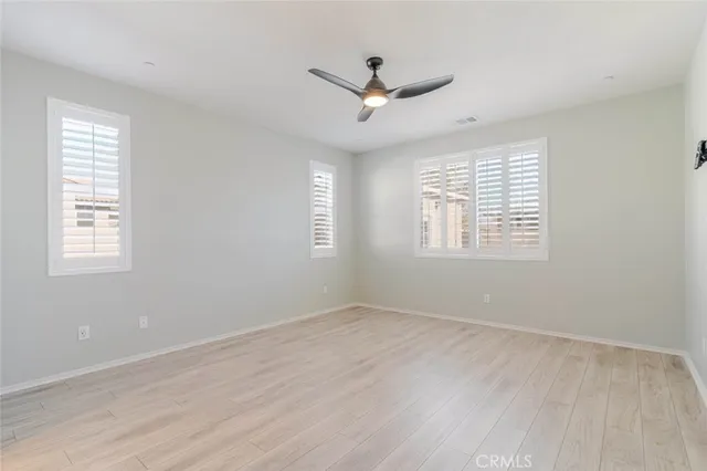 a view of a big room with wooden floor and windows