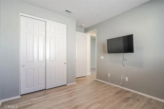 a view of room with hardwood floor and mirror