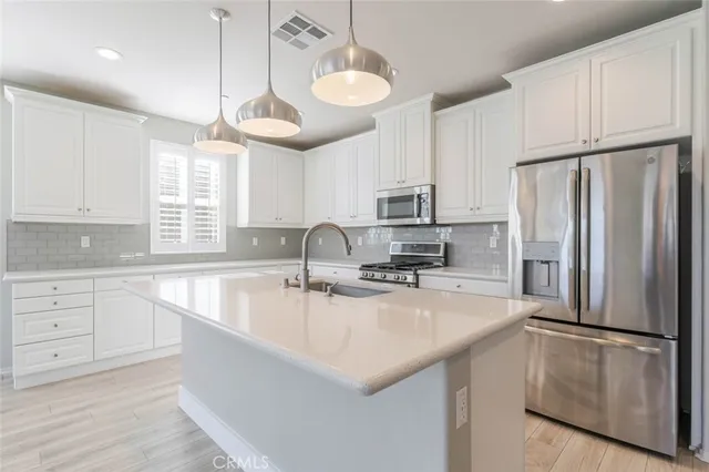 a kitchen with refrigerator cabinets and wooden floor