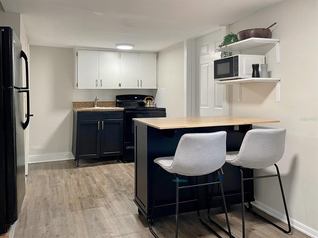 333 9th Avenue North, Unit B St. Petersburg, FL 33701 - Photo 2 of 8 a kitchen with kitchen island a counter top space cabinets and stainless steel appliances