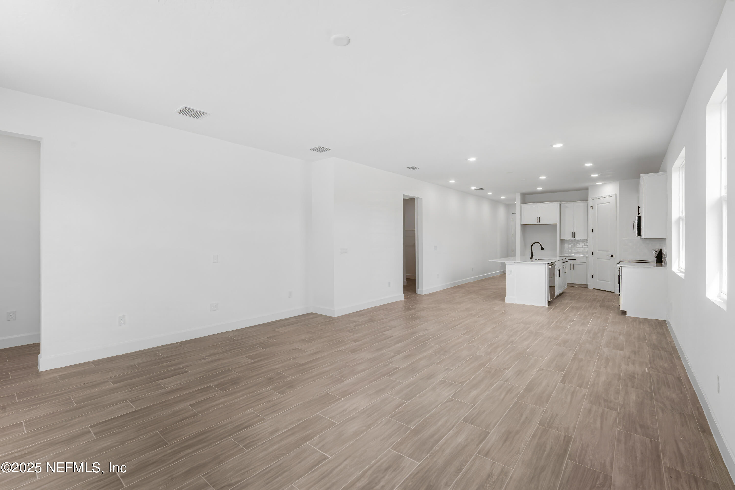 9049 Players Drive Weeki Wachee, FL 34613 - Photo 8 of 43 a view of a big room with wooden floor and large windows