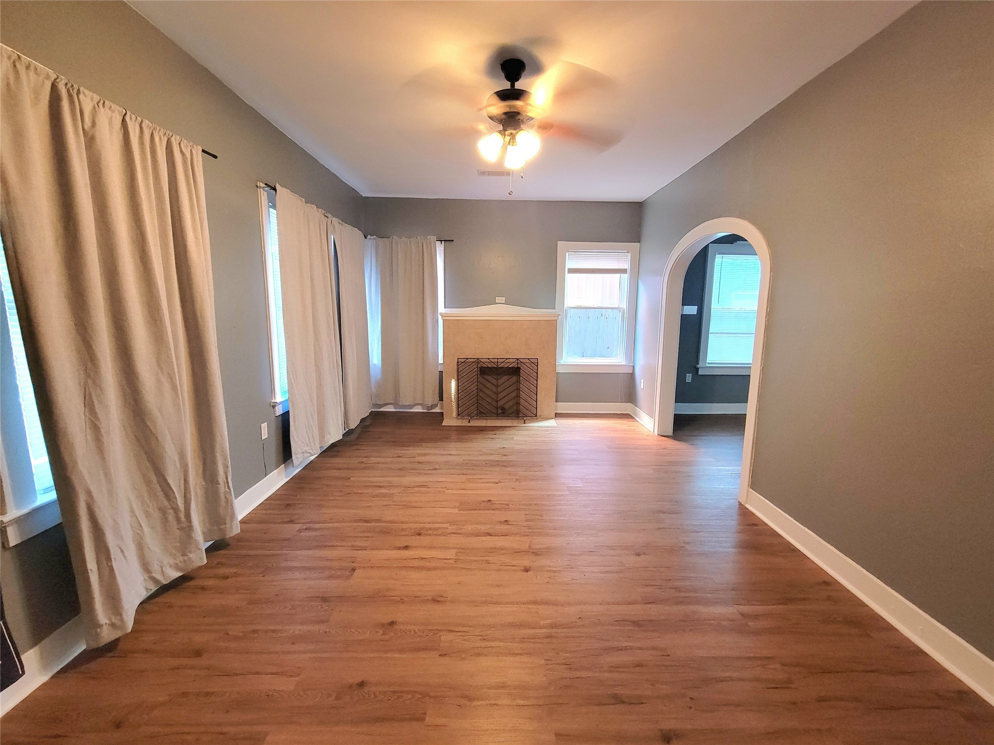2811 Chenevert Street Houston, TX 77004 - Photo 7 of 26 a view of a livingroom with wooden floor and a ceiling fan