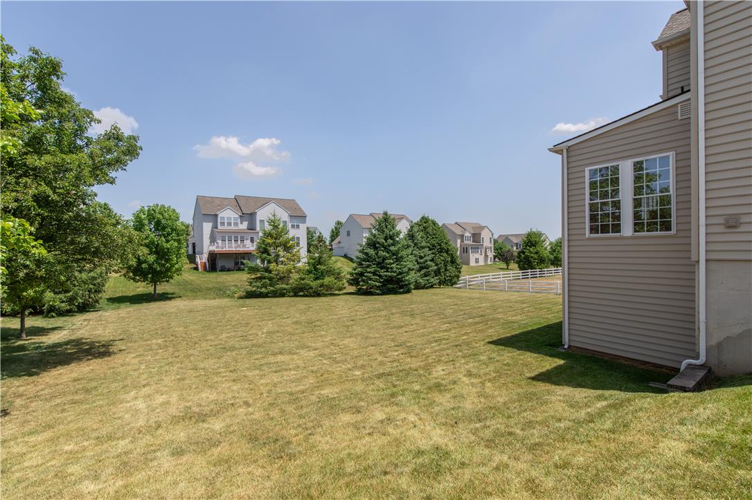 1709 Travers Road Breinigsville, PA 18031 - Photo 52 of 55 A spacious, manicured backyard with verdant trees, offering scenic community views and ample room for outdoor activities.