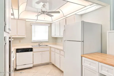 a kitchen with white cabinets and white appliances