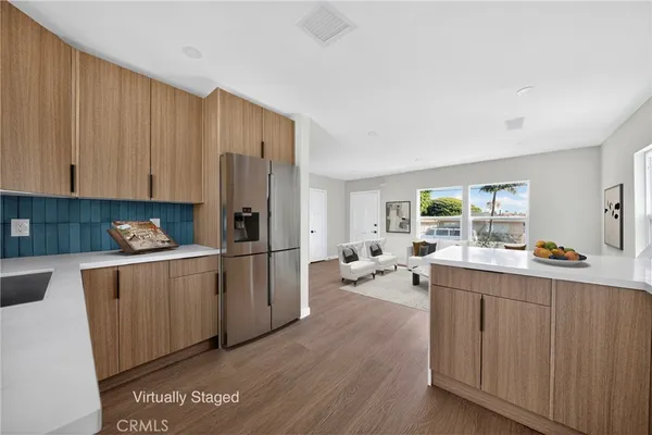 a kitchen with a refrigerator a stove top oven a sink dishwasher and wooden cabinets