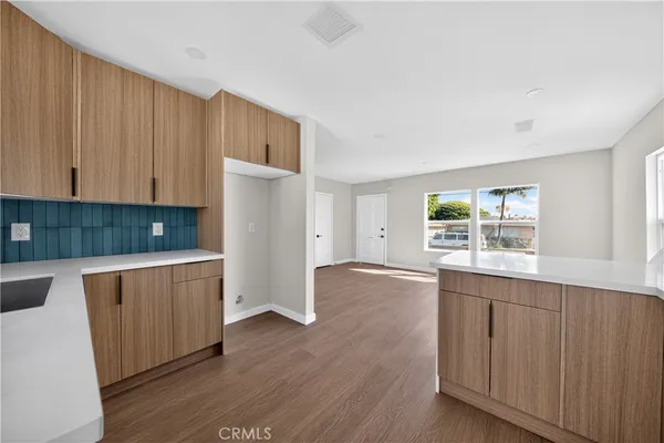 a kitchen with granite countertop wooden floors and white cabinets