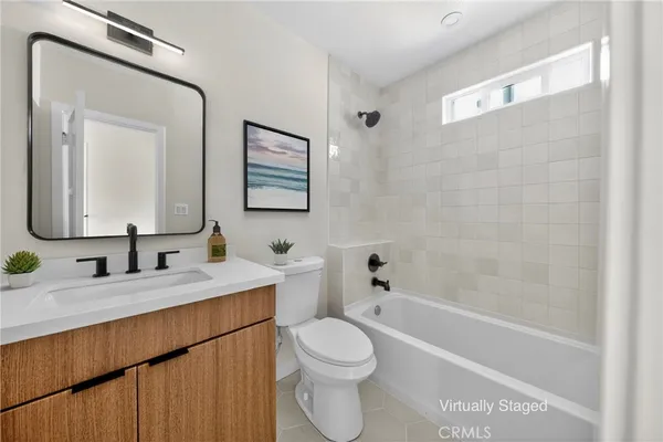 a bathroom with a toilet a sink a bathtub and a mirror