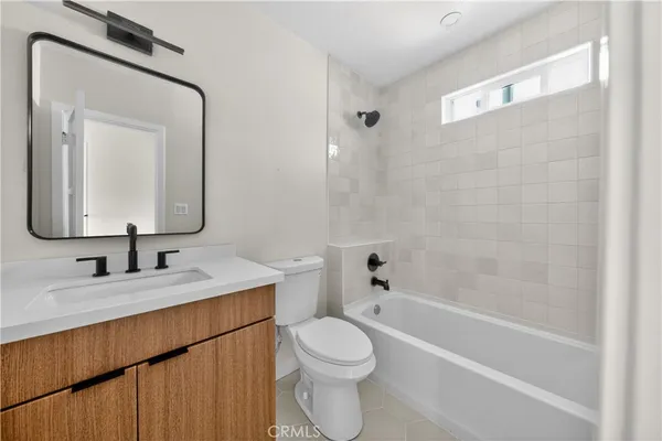 a bathroom with a toilet sink vanity tub and mirror