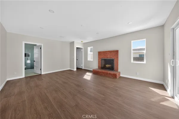 a view of empty room with wooden floor and fireplace