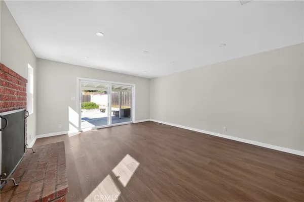 a view of empty room with wooden floor and fireplace