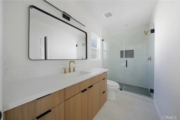 a bathroom with a sink a toilet and mirror