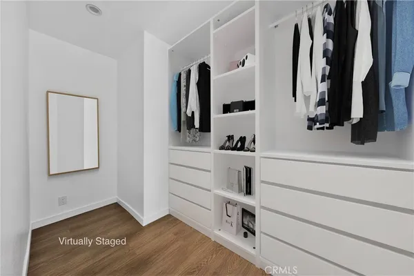 a view of walk in closet with clothes and shoes