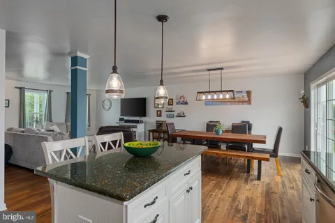 a kitchen with a table chairs and a wooden floor