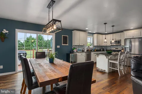 a kitchen with a dining table chairs stainless steel appliances and cabinets