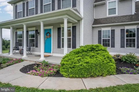 front view of a brick house with potted plant and flower plants