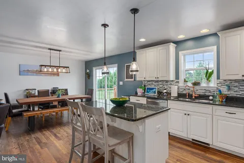 a kitchen with kitchen island granite countertop a sink a counter space appliances and cabinets
