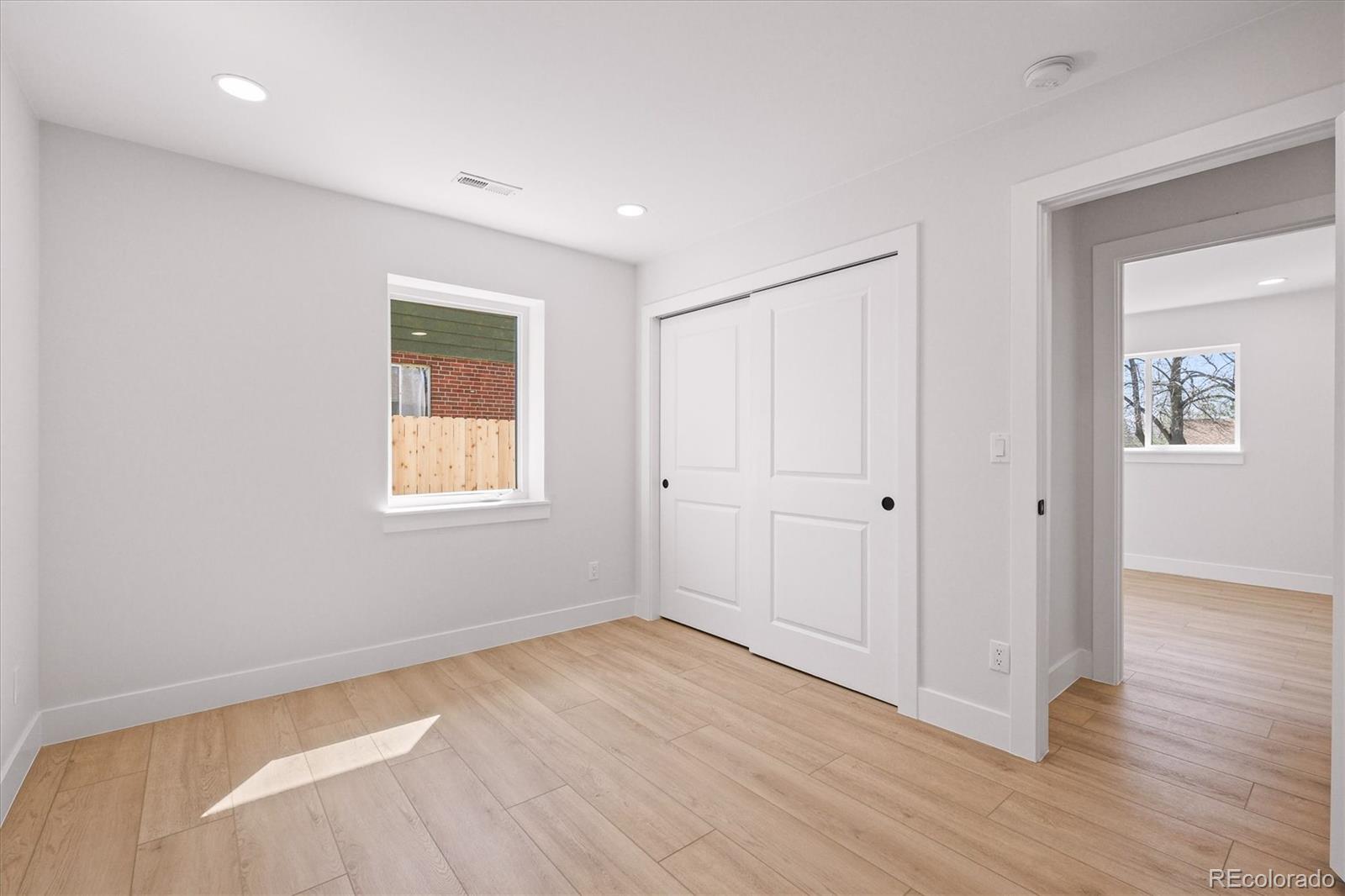 2950 South Adams Street Denver, CO 80210 - Photo 25 of 42 an empty room with wooden floor and windows