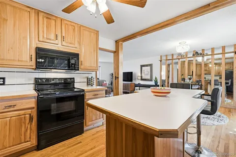 a large kitchen with kitchen island a large window a sink and stainless steel appliances