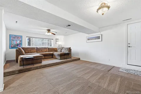 a kitchen with granite countertop a refrigerator a sink and white cabinets
