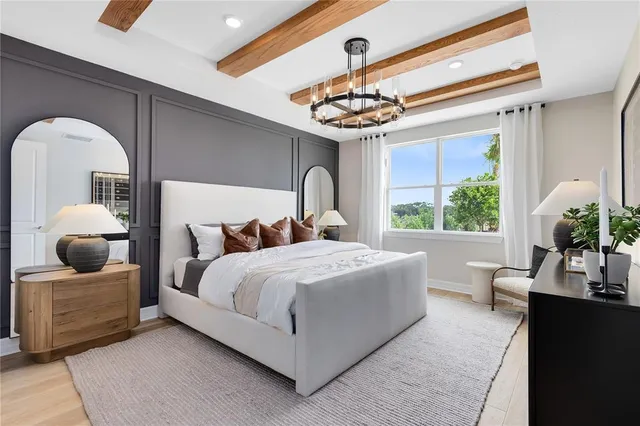 a bedroom with a bed and a chandelier