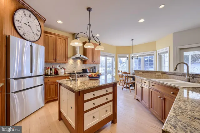 a kitchen with stainless steel appliances granite countertop a stove a sink a oven and a clock