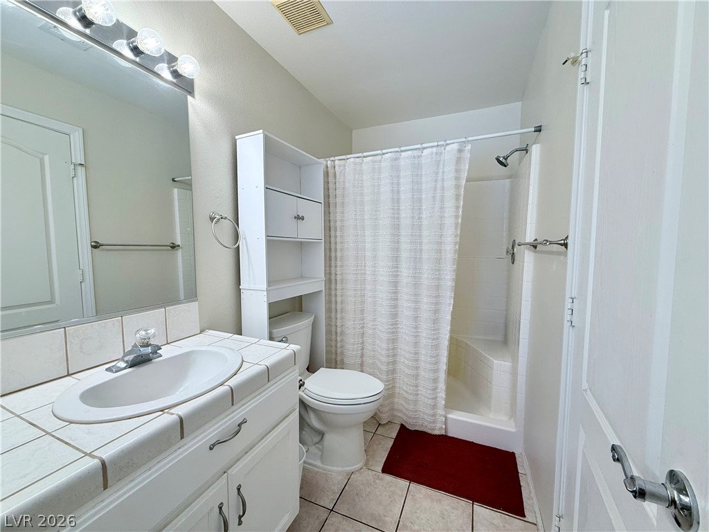 1220 East Gamebird Road Pahrump, NV 89048 - Photo 19 of 49 A well-maintained bathroom offers a practical tiled vanity and a clean shower space.
