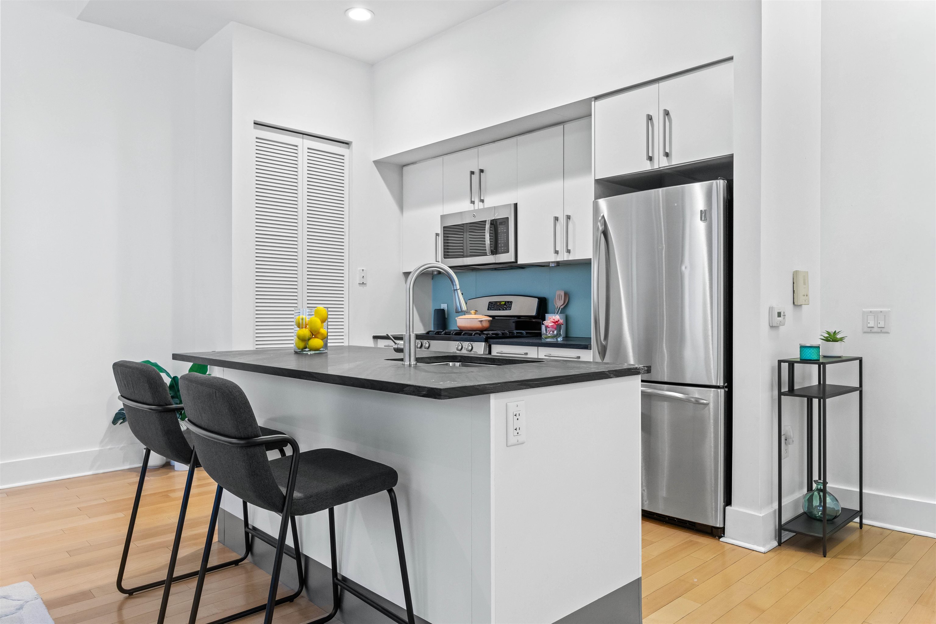 4 Beacon Way, Unit 211 Jersey City, NJ 07304 - Photo 2 of 22 a kitchen with stainless steel appliances granite countertop a refrigerator and a stove top oven