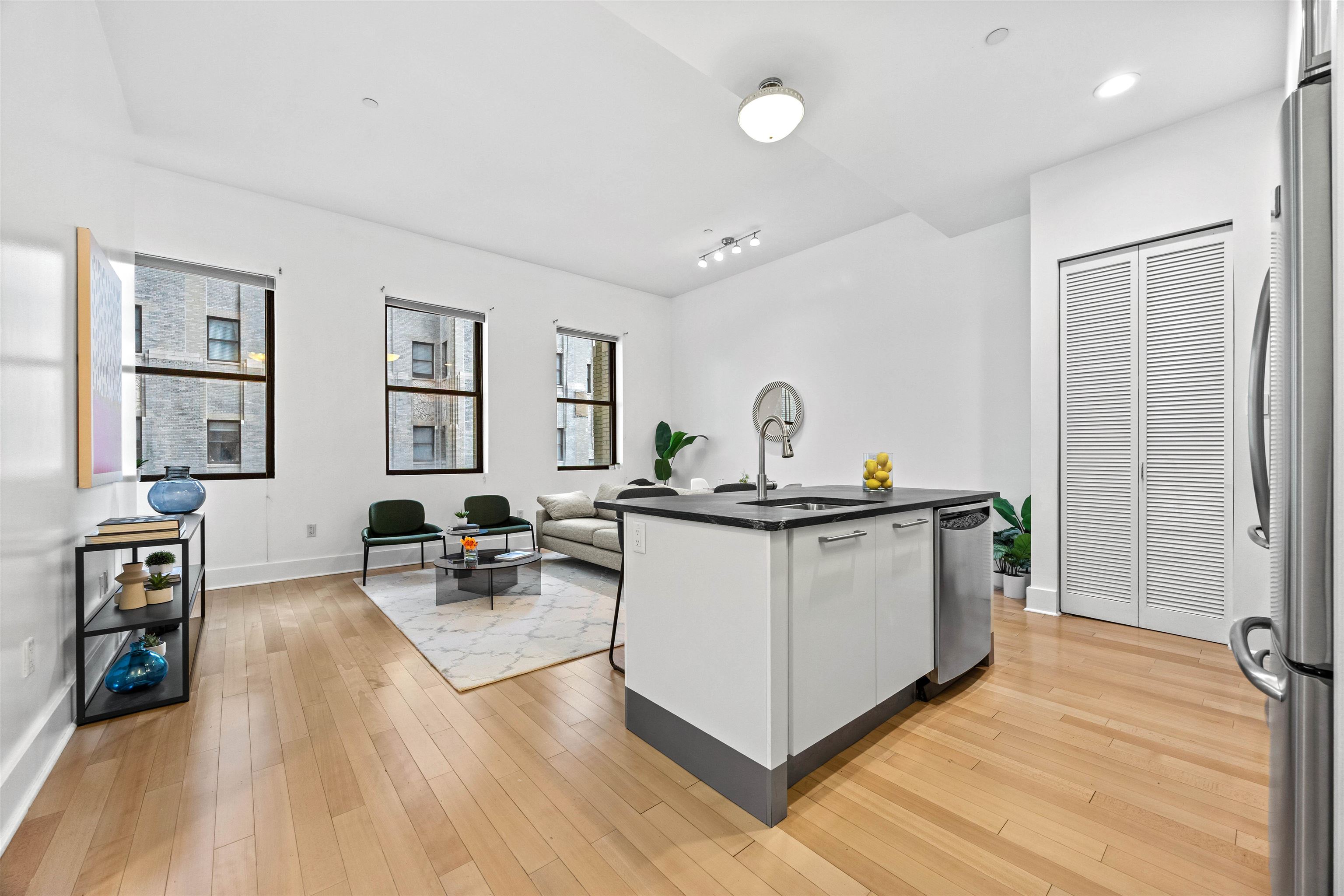 4 Beacon Way, Unit 211 Jersey City, NJ 07304 - Photo 4 of 22 a living room with stainless steel appliances kitchen island hardwood floor and a window
