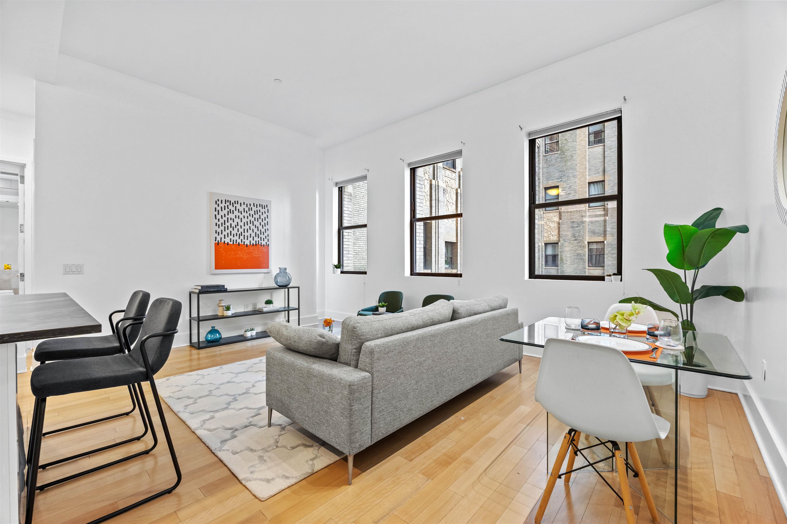 4 Beacon Way, Unit 211 Jersey City, NJ 07304 - Photo 7 of 22 a living room with furniture and a potted plant