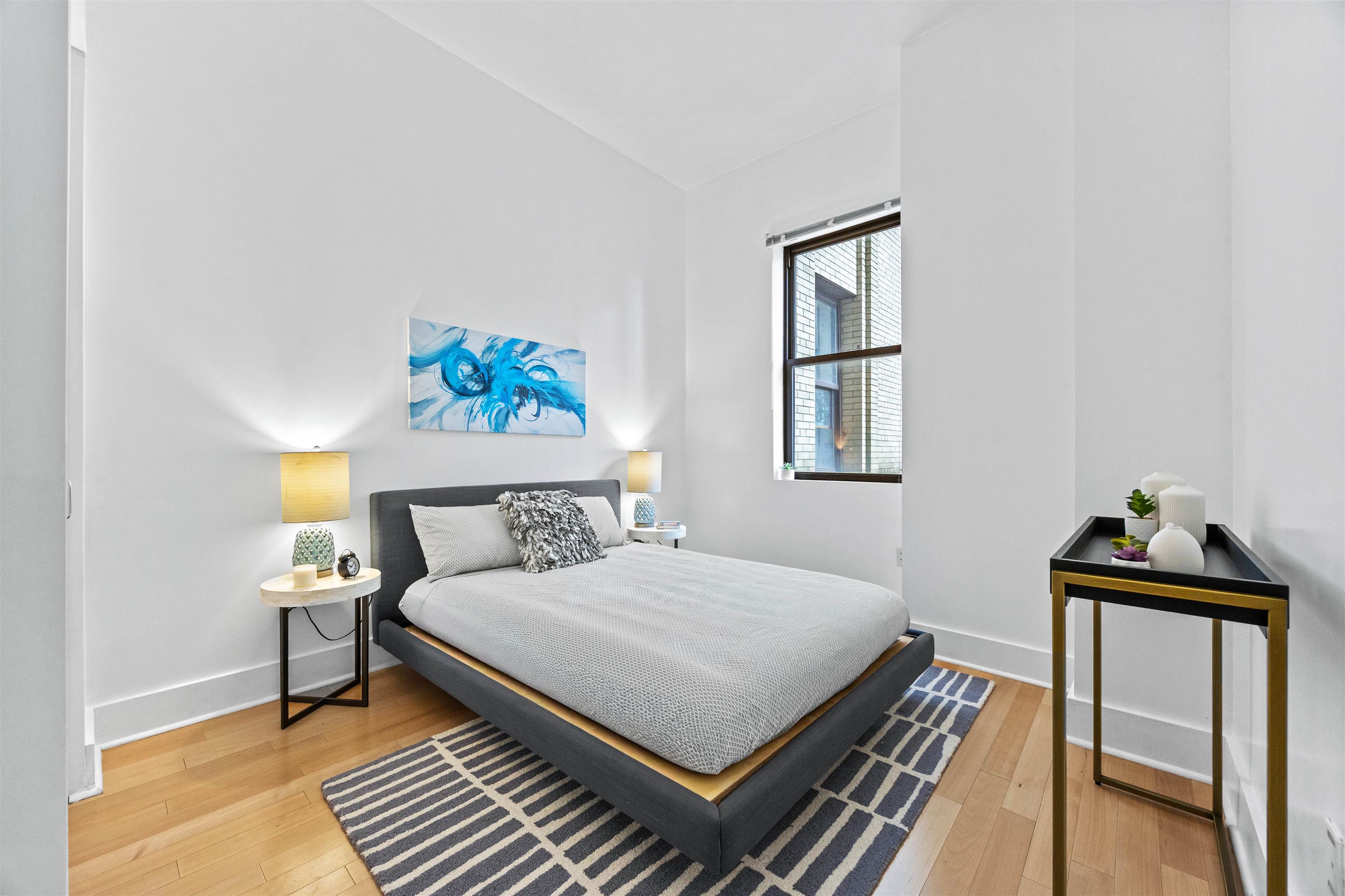 4 Beacon Way, Unit 211 Jersey City, NJ 07304 - Photo 8 of 22 a bedroom with a bed and wooden floor