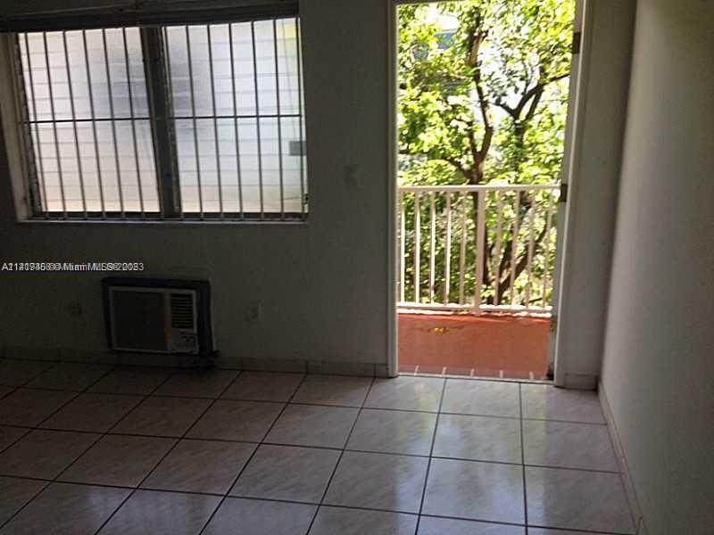 7720 Harding Avenue, Unit 11 Miami Beach, FL 33141 - Photo 3 of 7 a view of a livingroom with an empty space and a window