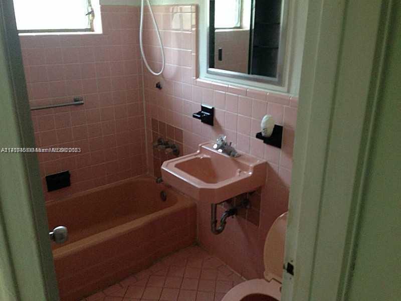 7720 Harding Avenue, Unit 11 Miami Beach, FL 33141 - Photo 4 of 7 a bathroom with a sink and a mirror