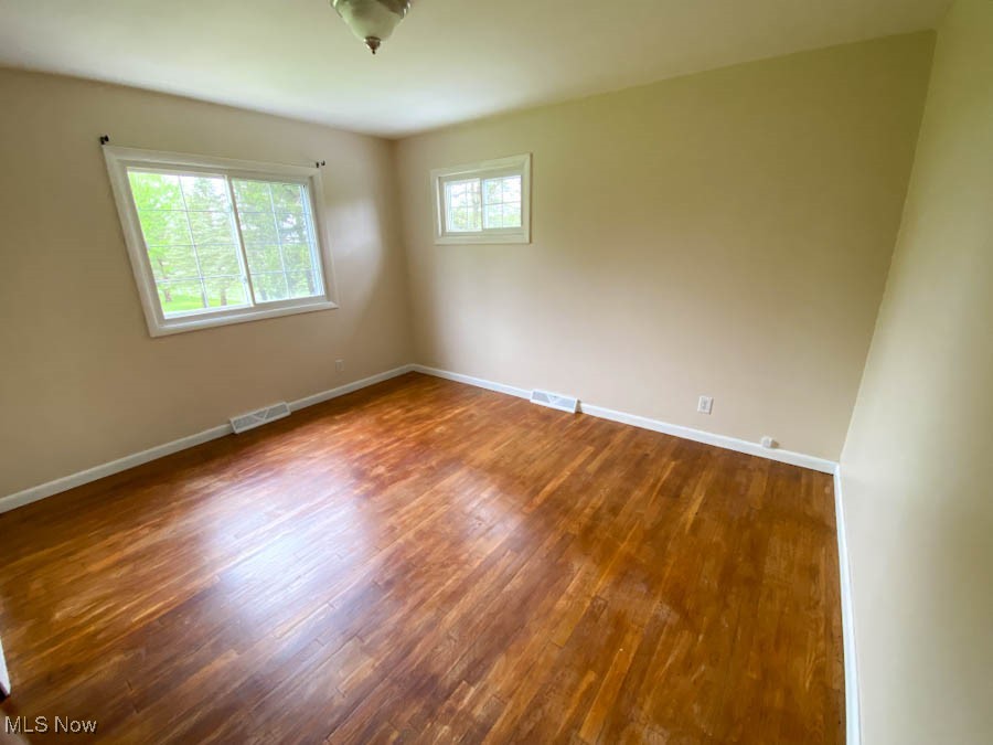 751 Garrison Road Ashtabula, OH 44004 - Photo 9 of 19 Spare room with baseboards, dark wood-style flooring, and visible vents