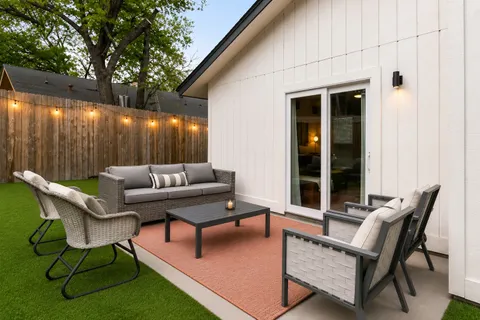 a backyard of a house with barbeque oven and wooden fence