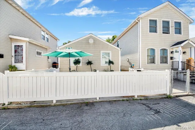 a front view of a house with white fence