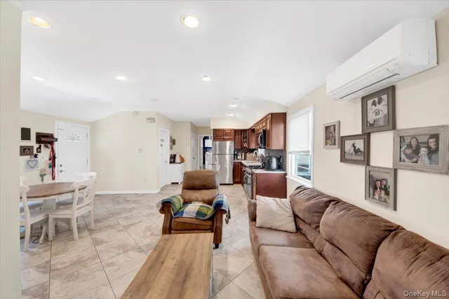 a living room with furniture and a refrigerator