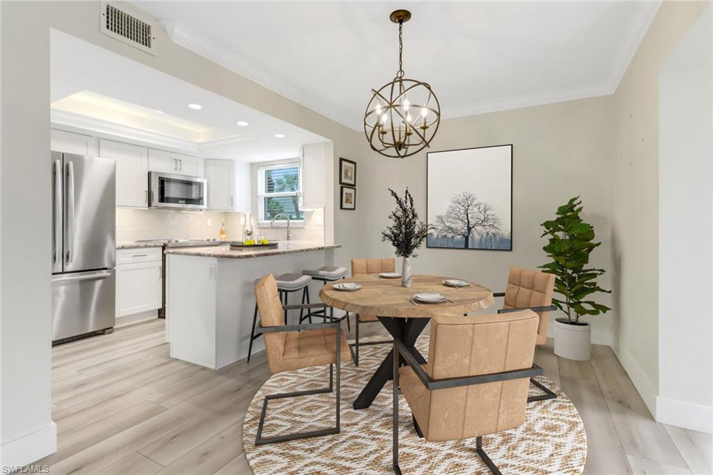 a view of a dining room and kitchen with furniture wooden floor and a chandelier