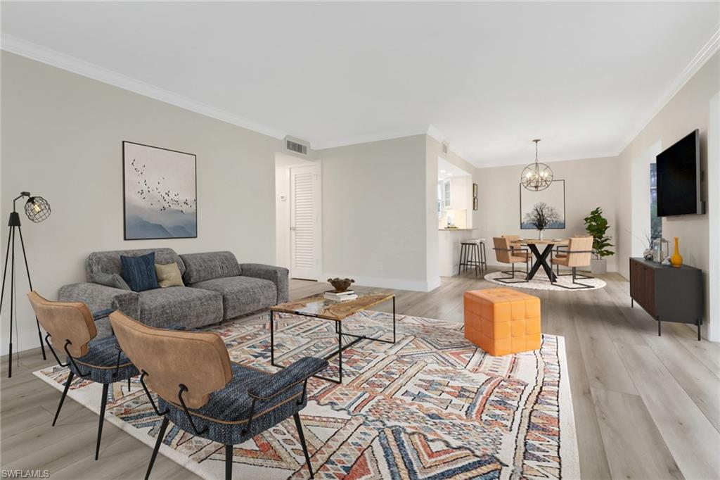 1549 Sandpiper Street, Unit 1 Naples, FL 34102 - Photo 3 of 16 a living room with furniture a flat screen tv and kitchen view