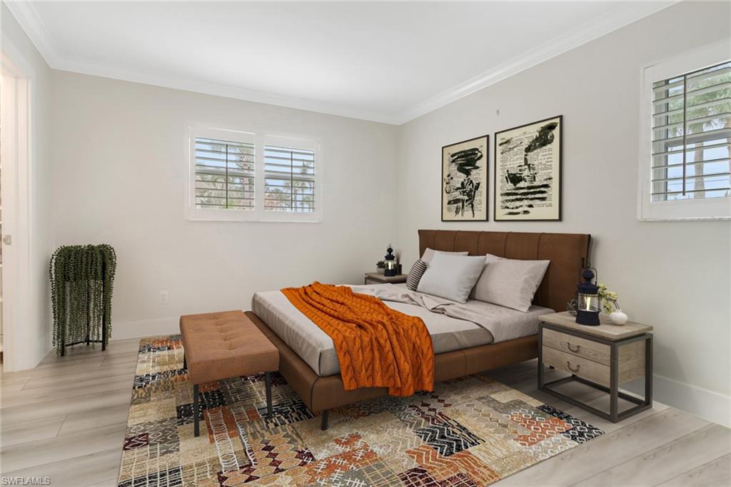 1549 Sandpiper Street, Unit 1 Naples, FL 34102 - Photo 8 of 16 a bedroom with a bed and a dresser with wooden floor